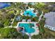 Aerial view of community pools with lounging areas and a playground, all surrounded by lush landscaping at 11435 Fort Lauderdale Pl, Venice, FL 34293