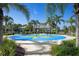Community splash pad with blue mat, water features, and a shaded pavilion, surrounded by lush landscaping at 11435 Fort Lauderdale Pl, Venice, FL 34293