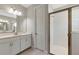 Bathroom featuring double sinks with white vanities, a frameless glass shower, and tile flooring at 12613 Oak Hill Way, Parrish, FL 34219