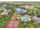Aerial shot of the community amenities: pool, tennis and basketball courts, and playground by the lake at 12642 Cara Cara Loop, Bradenton, FL 34212