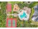 Aerial perspective of pool with slides, playground, tennis and basketball courts surrounded by trees at 12642 Cara Cara Loop, Bradenton, FL 34212