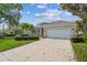 Inviting front exterior with lush landscaping, a two-car garage, and a well-maintained lawn at 12642 Cara Cara Loop, Bradenton, FL 34212