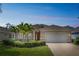 Charming single-story home with a two-car garage, manicured landscaping, and beautiful palm trees at 12642 Cara Cara Loop, Bradenton, FL 34212