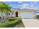 Charming single-story home with a two-car garage, manicured landscaping, and beautiful palm trees at 12642 Cara Cara Loop, Bradenton, FL 34212