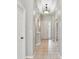 Elegant hallway featuring arched doorways, decorative lighting, neutral paint, and light tile flooring at 12642 Cara Cara Loop, Bradenton, FL 34212