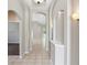 Elegant hallway featuring arched doorways, decorative lighting, neutral paint, and light tile flooring at 12642 Cara Cara Loop, Bradenton, FL 34212