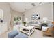 Comfortable living room featuring a neutral color palette, stylish furnishings, and sliding glass doors to the backyard at 12642 Cara Cara Loop, Bradenton, FL 34212
