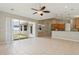 Spacious living room with tile flooring, ceiling fan, and sliding glass doors to the outdoor space at 12642 Cara Cara Loop, Bradenton, FL 34212