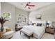 Bright main bedroom with sitting area, red ceiling fan, and large windows providing lots of natural light at 12642 Cara Cara Loop, Bradenton, FL 34212