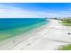Breathtaking aerial view of a white sand beach, crystal-clear turquoise water and beachgoers at 1280 Dolphin Bay Way # 204, Sarasota, FL 34242
