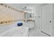 Bright bathroom featuring a large soaking tub with decorative tile surround and granite countertop vanity at 1280 Dolphin Bay Way # 204, Sarasota, FL 34242