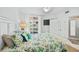 Bedroom with a queen bed with floral bedding, TV, outdoor view, and neutral walls at 1280 Dolphin Bay Way # 204, Sarasota, FL 34242