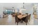 Open-concept dining area with views of living room, sunroom, and serene water view at 1280 Dolphin Bay Way # 204, Sarasota, FL 34242