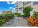 Exterior view featuring a multi story building, plants, sidewalk, and blue skies at 1280 Dolphin Bay Way # 204, Sarasota, FL 34242
