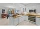 Open kitchen design with breakfast bar and stainless steel appliances and light colored tile at 1280 Dolphin Bay Way # 204, Sarasota, FL 34242