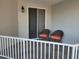 Cozy patio with tile floor, white railing, and chairs, perfect for relaxing outdoors at 1280 Dolphin Bay Way # 204, Sarasota, FL 34242