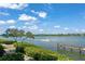 Beautiful water view with private dock, lush landscaping, and boat cruising by at 1280 Dolphin Bay Way # 204, Sarasota, FL 34242
