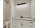 Bathroom featuring a marble countertop, white cabinets, black hardware, and toilet at 144 Spring Dr, Rotonda West, FL 33947