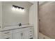 Modern bathroom featuring a marble countertop, white cabinets, and walk-in shower with light tile at 144 Spring Dr, Rotonda West, FL 33947