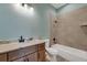 Modern bathroom featuring warm-toned wood cabinets, light countertops and a tub shower combo at 144 Spring Dr, Rotonda West, FL 33947