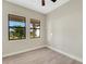 Light bedroom with a ceiling fan, plank flooring, and two large windows with tropical view at 144 Spring Dr, Rotonda West, FL 33947