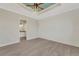 Spacious bedroom with tray ceiling, ceiling fan, plank flooring, and ensuite bathroom at 144 Spring Dr, Rotonda West, FL 33947