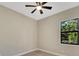 Cozy bedroom with a ceiling fan and a window view, offering a comfortable and relaxing atmosphere at 144 Spring Dr, Rotonda West, FL 33947