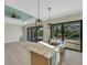 Open concept kitchen featuring an island with a sink, modern lighting, and glass doors to the lanai at 144 Spring Dr, Rotonda West, FL 33947