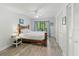 Bright bedroom features wood-look floors, ceiling fan, and screened sliding glass doors to enjoy the lush landscaping outside at 157 Pinehurst Dr # 157, Bradenton, FL 34210