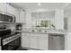 Modern kitchen with stainless steel appliances and pass-through to living area at 157 Pinehurst Dr # 157, Bradenton, FL 34210