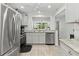 Modern kitchen with stainless steel appliances, granite countertops, and wood-look flooring at 157 Pinehurst Dr # 157, Bradenton, FL 34210