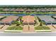 Aerial view of a home with a brown tile roof, set between a lake and numerous other homes at 15707 Sacile Ln, Bradenton, FL 34211