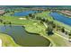 Aerial view of a scenic golf course featuring lush greens, water features and mature landscaping at 15707 Sacile Ln, Bradenton, FL 34211