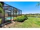 Expansive backyard featuring a screened-in pool and a picturesque view of the lake and community at 15707 Sacile Ln, Bradenton, FL 34211