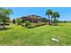 Manicured backyard featuring a screened lanai, vibrant landscaping, and lush green lawn at 15707 Sacile Ln, Bradenton, FL 34211