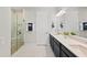 Bathroom featuring a double vanity, large mirror, and glass-enclosed shower at 15707 Sacile Ln, Bradenton, FL 34211