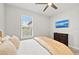Comfortable bedroom featuring a TV, ceiling fan, and a window with natural light, creating a cozy atmosphere at 15707 Sacile Ln, Bradenton, FL 34211