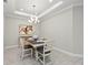Well-lit dining room with modern chandelier, tile floors, and neutral decor at 15707 Sacile Ln, Bradenton, FL 34211