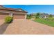Wide, brick-paved driveway leads to a two-car garage with manicured lawn at 15707 Sacile Ln, Bradenton, FL 34211