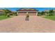 Home featuring a two-car garage, brick paved driveway and landscaping at 15707 Sacile Ln, Bradenton, FL 34211