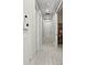 Well-lit hallway with wood-look tile flooring, several doors, and recessed lighting at 15707 Sacile Ln, Bradenton, FL 34211