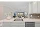 Kitchen island with undermount sink provides views to the living room and outdoor spaces through large sliding glass doors at 15707 Sacile Ln, Bradenton, FL 34211