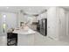 Well-lit kitchen features modern stainless steel appliances, white cabinets, and tiled floors at 15707 Sacile Ln, Bradenton, FL 34211