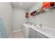 Well-organized laundry room featuring a modern washer and dryer, sink, and convenient overhead shelving at 15707 Sacile Ln, Bradenton, FL 34211