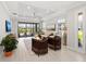 Bright living room with high ceilings, ceiling fan, and sliding glass doors to the lanai and pool at 15707 Sacile Ln, Bradenton, FL 34211