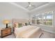 Serene main bedroom features tray ceilings, a ceiling fan, and bright windows at 15707 Sacile Ln, Bradenton, FL 34211