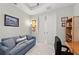Cozy office space with a desk, bookcase, comfortable blue sofa, and a sliding door to another room at 15707 Sacile Ln, Bradenton, FL 34211