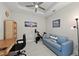 Office featuring a desk, blue sofa, stationary bike, and scenic artwork, blending productivity and relaxation at 15707 Sacile Ln, Bradenton, FL 34211