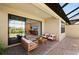Covered patio with comfortable seating and an open view through sliding glass doors to the home's interior at 15707 Sacile Ln, Bradenton, FL 34211