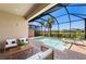 Picturesque screened-in pool and spa with patio seating and a view of the surrounding tropical landscape at 15707 Sacile Ln, Bradenton, FL 34211